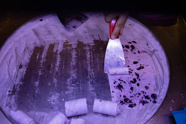 Woman hand making ice cream on round cold plate - Photo, Image