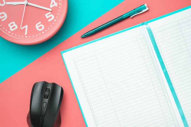 notebook vista superior com uma caneta e um relógio e um mouse de computador em um fundo colorido
 - Foto, Imagem