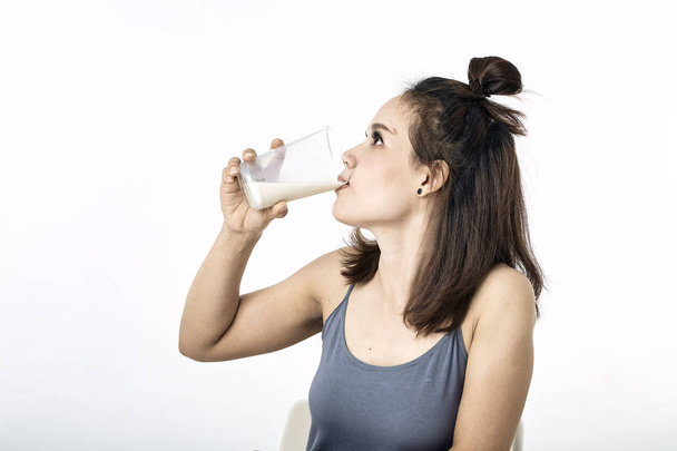Nuori nainen juo maitoa pöydällä
 - Valokuva, kuva