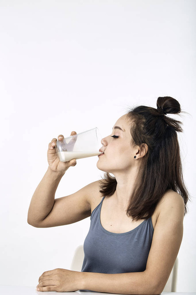 giovane donna che beve latte sul tavolo
 - Foto, immagini