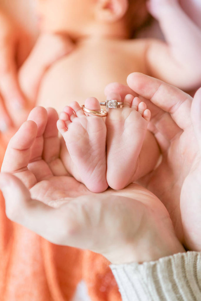 Children's feet in hands of mother and father. Mother, father and Child. Happy Family concept. Beautiful conceptual image of Motherhood - Foto, Bild