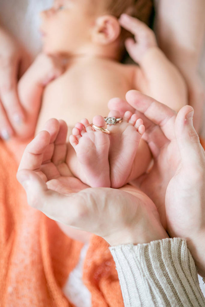 Children's feet in hands of mother and father. Mother, father and Child. Happy Family concept. Beautiful conceptual image of Motherhood - Foto, Bild