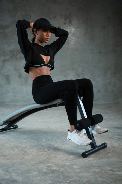 Zdrowa kobieta robi awarii ABS na siłowni. Kobieta w odzieży sportowej robi trening brzucha w studio fitness - Zdjęcie, obraz