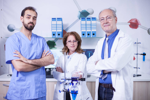 Πορτραίτο τριών επιστημόνων ντυμένοι με τη στολή τους σε ένα εργαστήριο - Φωτογραφία, εικόνα