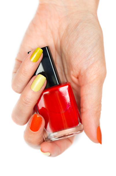 A bottle of red nail polish in a female hand - Фото, зображення