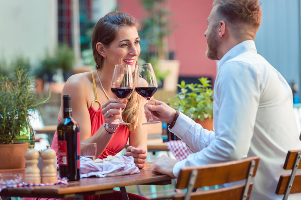 Jeune couple ayant du vin rouge au restaurant
 - Photo, image