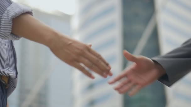 Aziatische zakenman schudden handen close-up na een werk hebben succes en prestatie staan in een stedelijke stad. Slow-Motion lage hoek shoot. - Video