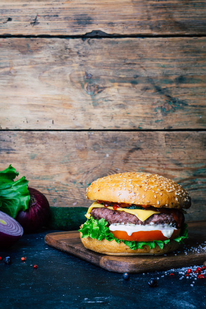 hausgemachter Burger (Cheeseburger) mit Rindfleisch auf Holzgrund - Foto, Bild