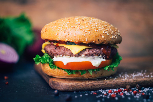 Бургер собственного производства (чизбургер) с говядиной на деревянном фоне
 - Фото, изображение
