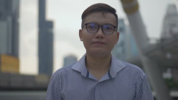 Portrait handsome Asian businessman talking phone with a friend walking on the urban city. Slow-motion shoot. - Séquence, vidéo