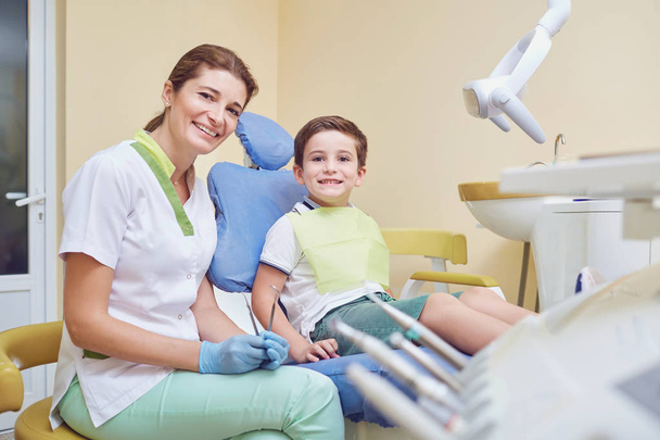 Adult dentist with little patient in hospital office - Foto, immagini