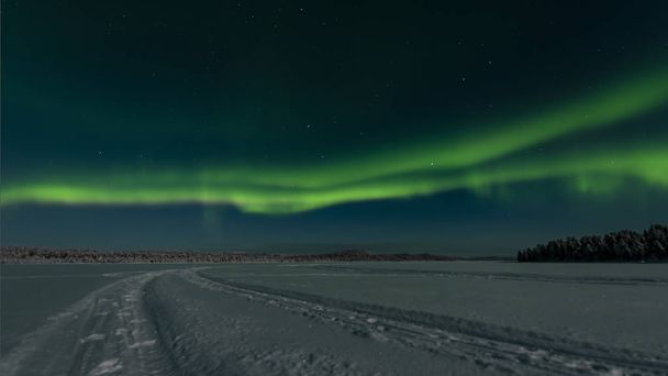 ooking across a frozen lake to the northern lights - Photo, Image