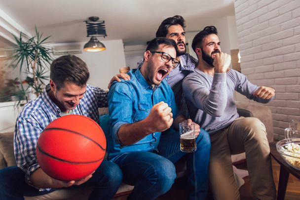Happy friends or basketball fans watching basketball game on tv  - Foto, Imagem
