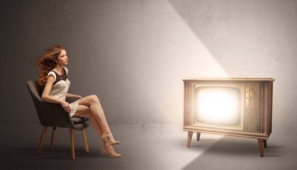 Young lady watching to a vintage television - Foto, Imagen