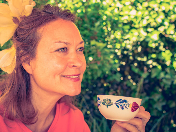 Donna di mezza età sorridente e godendo il suo caffè
. - Foto, immagini