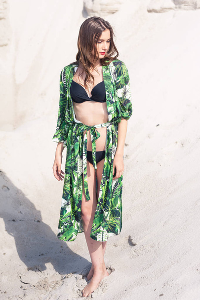 Hermosa mujer joven que se enfría en la playa en traje de baño verde
 - Foto, imagen