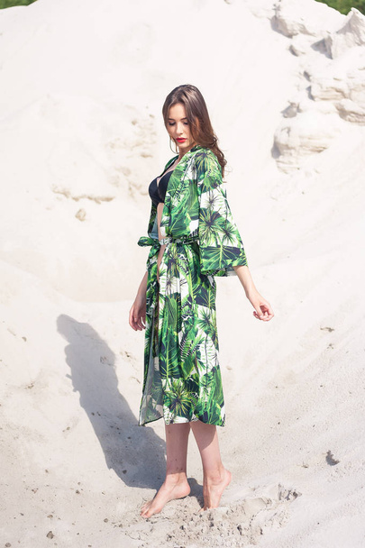 Hermosa mujer joven que se enfría en la playa en traje de baño verde
 - Foto, imagen