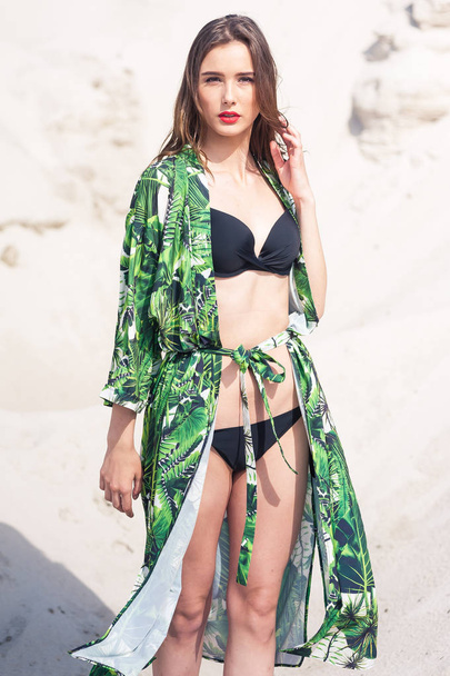 Beautiful young woman chilling on the beach in green swimwear - Photo, Image