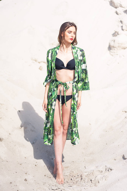 Красива молода жінка охолоджує на пляжі в зеленому купальнику
 - Фото, зображення