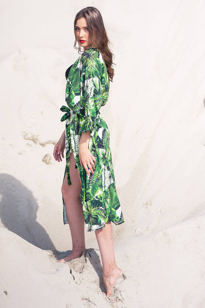 Belle jeune femme se rafraîchissant sur la plage en maillot de bain vert
 - Photo, image