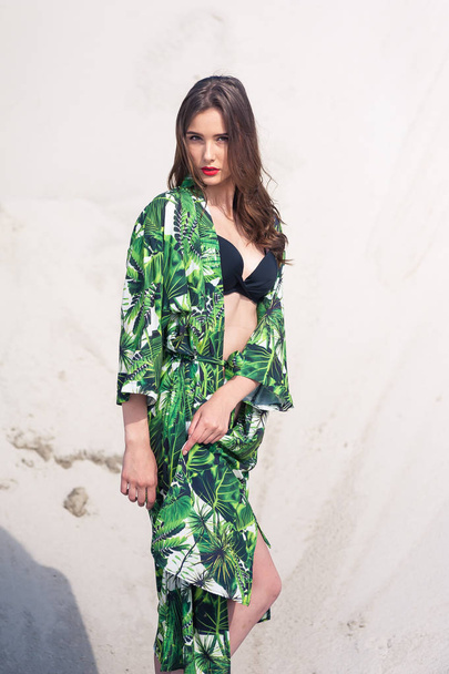 Belle jeune femme se rafraîchissant sur la plage en maillot de bain vert
 - Photo, image