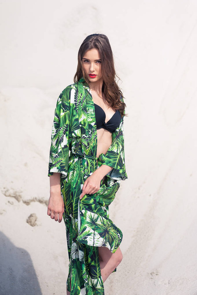 Szép fiatal nő hűtés a tengerparton, zöld fürdőruhák - Fotó, kép