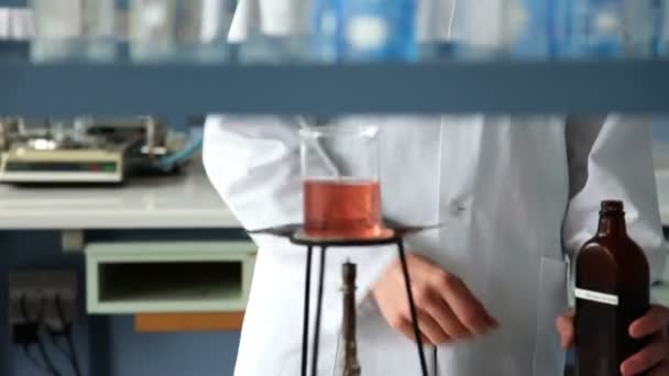 Girato del giovane studente mescolando un po 'di liquido sul fuoco come parte dell'esperimento
 - Filmati, video