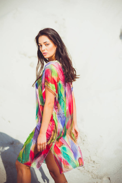 Krásná mladá smyslná žena na písku v barevném plavním oblečení - Fotografie, Obrázek