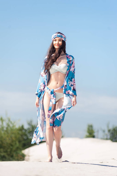 Beautiful sexy woman summer blue swimwear posing against the sky - 写真・画像