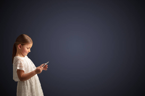 Cute little girl using tablet with dark background - Photo, Image