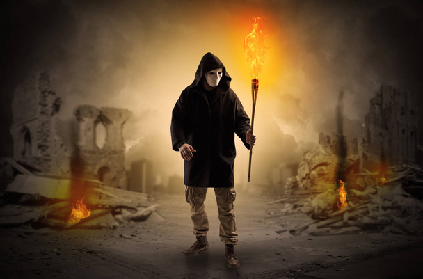 Man coming with burning flambeau at a catastrophe scene concept - Foto, Imagen