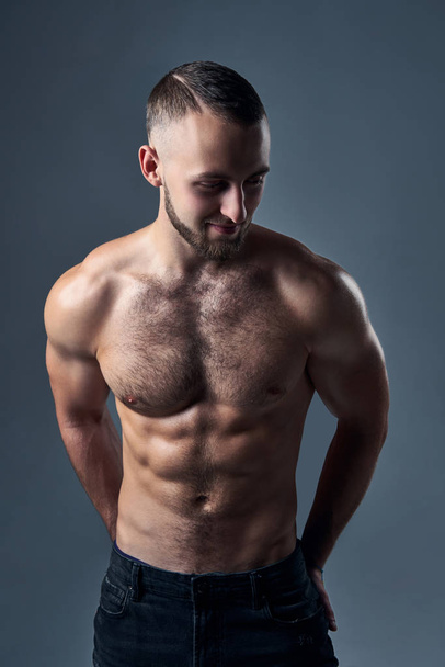 Muscular shirtless man standing with hands in pockets - Photo, Image