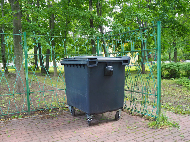 Propre poubelle de la ville dans le parc sur fond d'arbres verts. Poubelle pour la collecte de matériaux recyclés. Conteneur à ordures en plastique
. - Photo, image