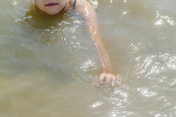 Das Baby ertrinkt im Wasser. Selektiver Fokus. - Foto, Bild