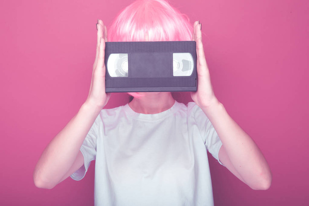 Young girl 90s and VHS cassette on pink - Photo, Image