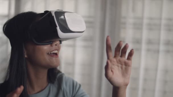 Close up attractive portrait beautiful young Asian woman playing a game and watching the movie in VR glasses. Happy Asian girl using 3D virtual reality headset at home. - Footage, Video