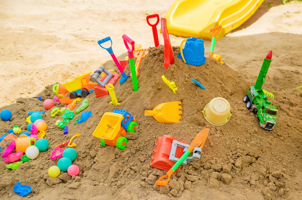 много детских игрушек в песочнице. Селективный фокус
. - Фото, изображение
