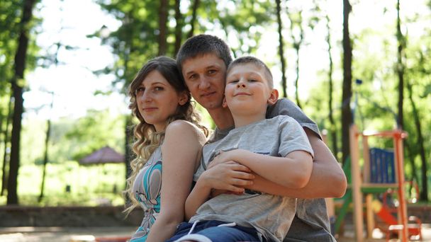Portrait of a young parents with son in a summer park. Mom, dad  - Фото, изображение