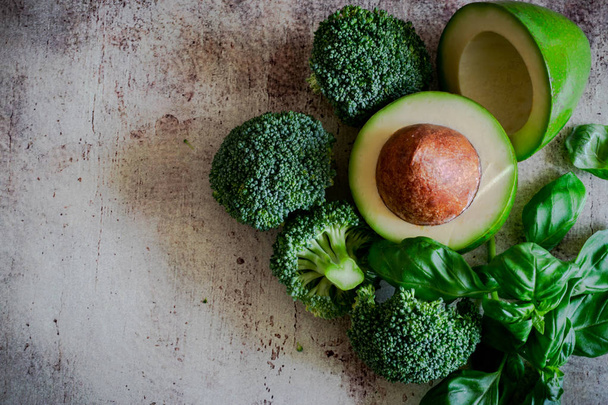 Ripe vegetables and fruits: broccoli, avocado and Basil on a beautiful background. - Photo, Image