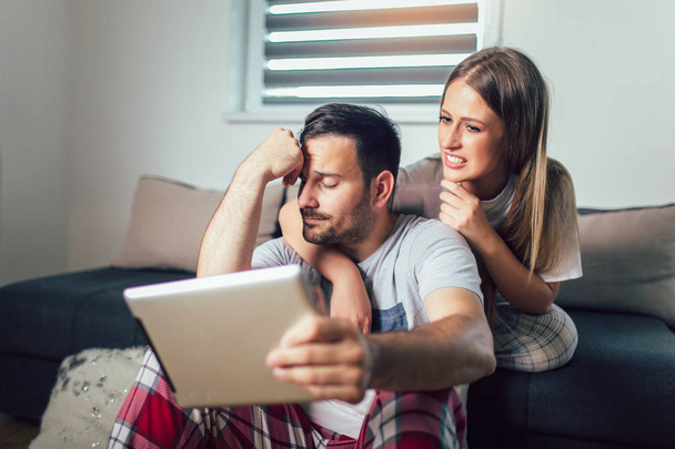 Veselý pár používající tablet on-line v obývacím pokoji - Fotografie, Obrázek