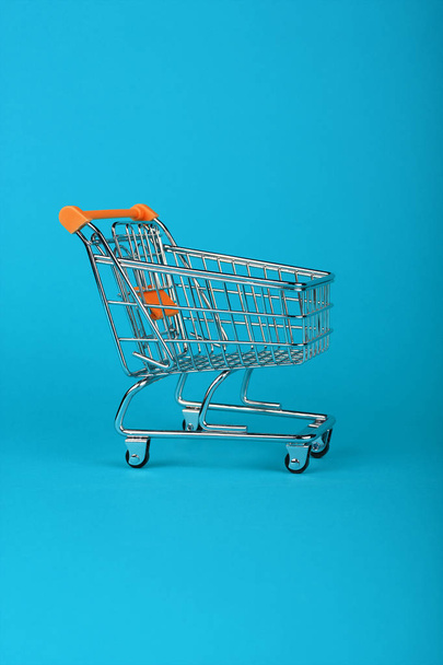 Lähikuva vähittäiskaupan ostoskori sinisellä pohjalla - Valokuva, kuva