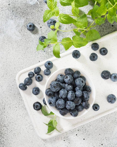 Blueberries in a white bowl on a light background - Fotografie, Obrázek