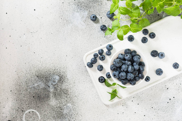 Blueberries in a white bowl on a light background - Photo, Image