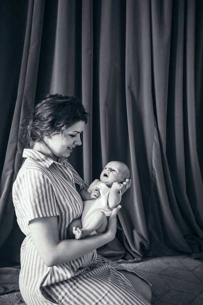 молодая женщина с младенцем на руках
  - Фото, изображение