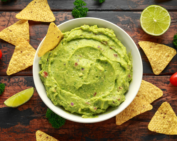 Bowl of fresh Guacamole with nachos chips and herbs. Healthy Vegan, Vegetables food. - Photo, Image