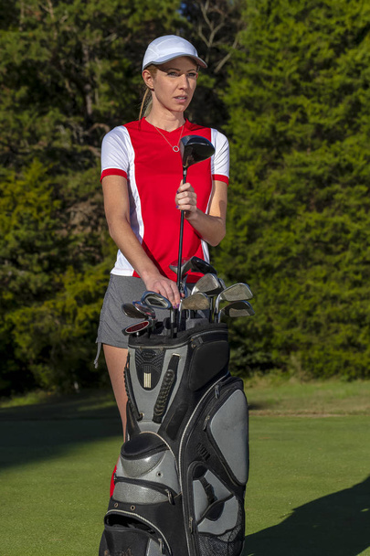 schöne blonde Golferin genießt eine Runde Golf auf einem öffentlichen Golfplatz - Foto, Bild