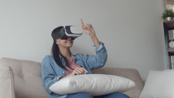 Attractive portrait young Asian woman wearing a VR headset in the living room, playing the game, watching a movie. Wearing virtual reality headset. - Filmati, video