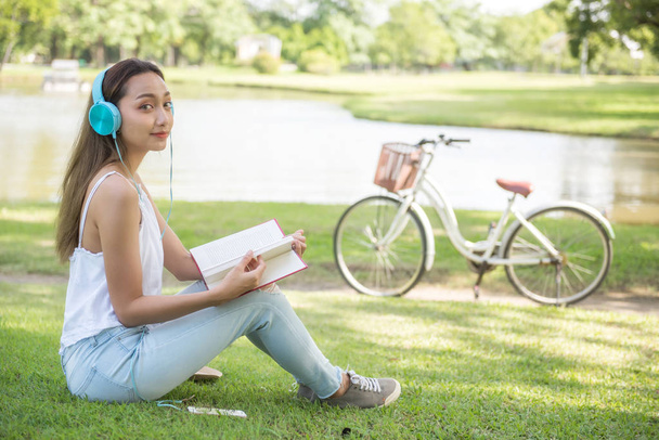 жінка читає книгу в літньому парку
 - Фото, зображення