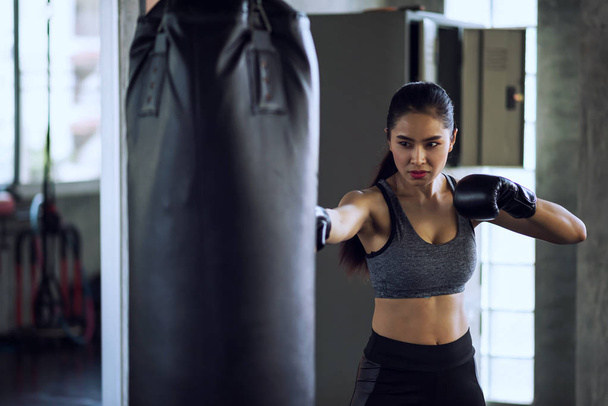 Woman boxer punch punching bag at gym - 写真・画像