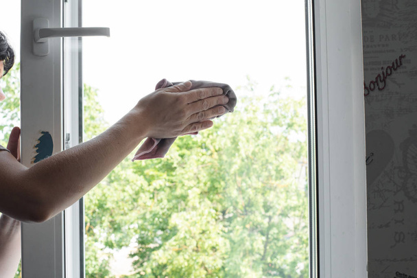 Travailleur masculin gardant chiffon dans la main et essuyant la fenêtre
 - Photo, image